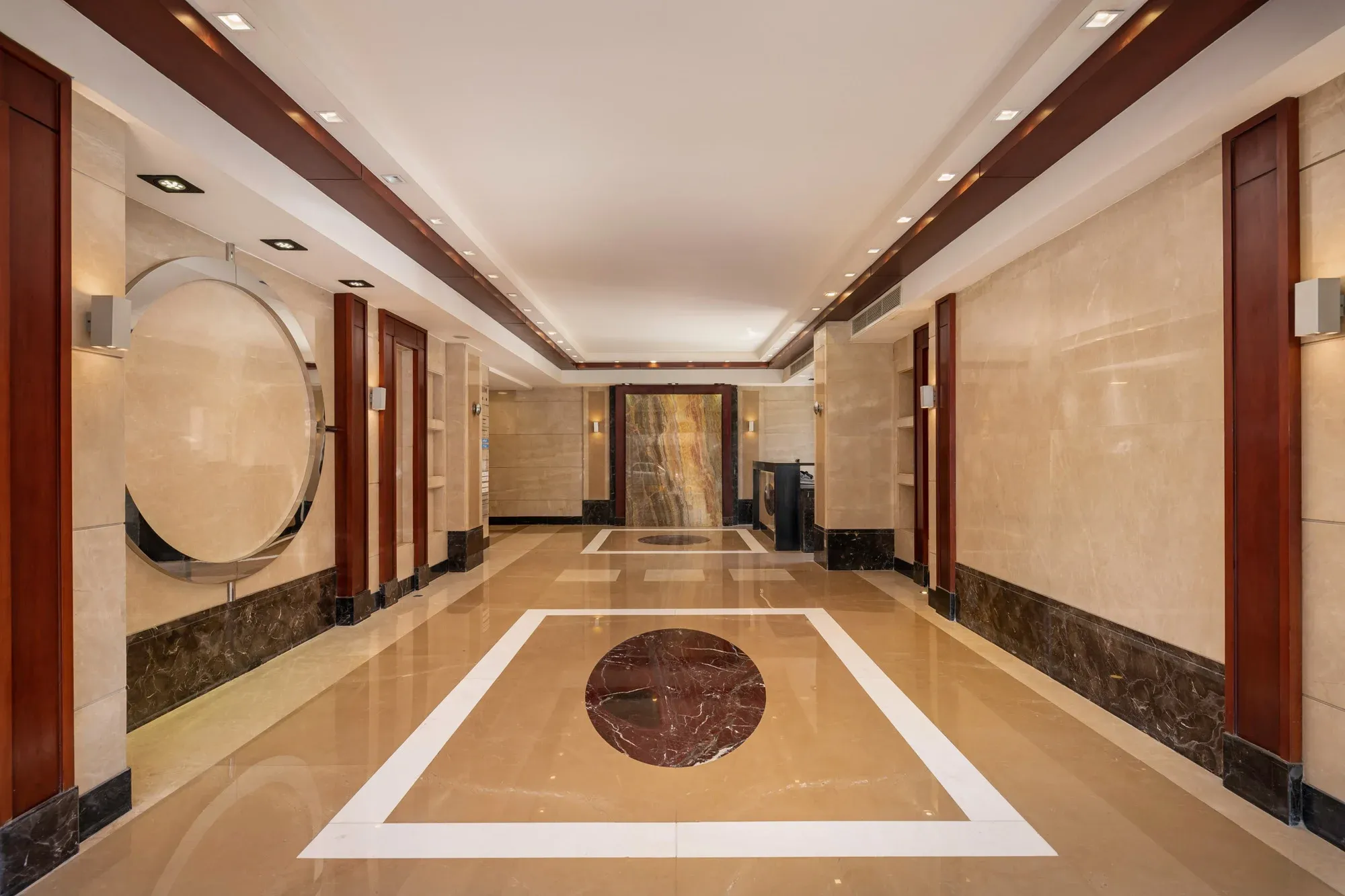 Polished stone lobby and timber-lined corridor inside a corporate office